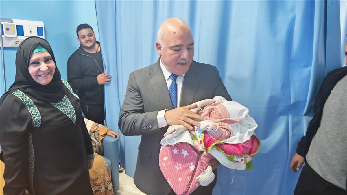 وكيل وزارة الصحة يحمل المولود