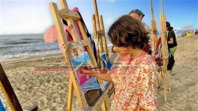 أطفال ينصبون مرسمًا على شواطئ مصيف بلطيم للتعبير عن صفاء المياه والشمس الساطعة