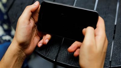 مجموعة من الشباب والمطورين ينفذون لعبة إلكترونية على الهواتف المحمولة تحمل اسم 