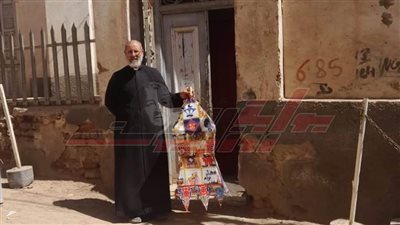 الأب أرميا راعي كنيسة السيدة العذراء مريم ببني عبيد بالمنيا يعلق فانوس احتفالا برمضان (صور)
