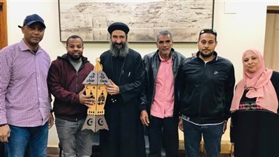 مُرتديًا زيه الرسمي.. قس يوزع فانوس رمضان على العاملين بأبوسمبل في أسوان