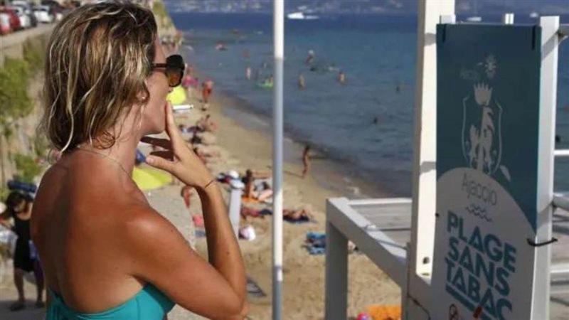 فرنسية تدخن على الشاطىء