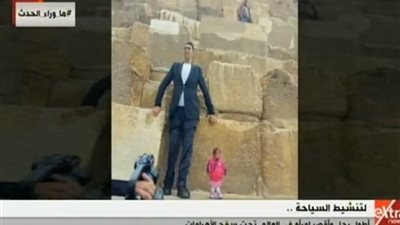أطول رجل وأقصر امرأة في العالم يروجان للسياحة المصرية أسفل سفح الأهرامات (فيديو)