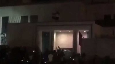 عراقي يرفع علم بلاده أعلى القنصلية الإيرانية في كربلاء