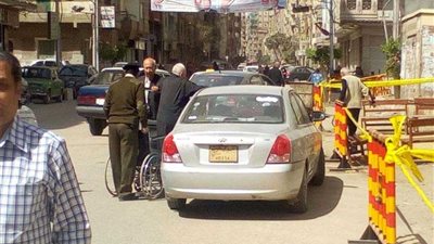 شرطي يصطحب ناخبا مريضا على كرسي متحرك للإدلاء بصوته