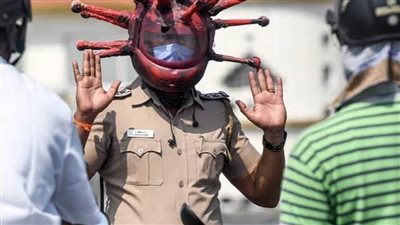 شرطي هندي يرتدي كورونا  لمنع سائقي الدراجات البخارية من السير