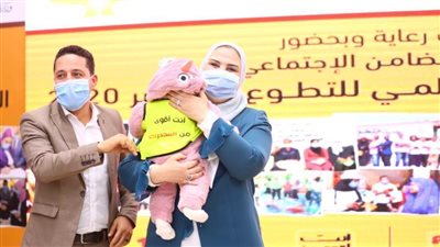 وزيرة التضامن تداعب طفلة لأسرة متطوعين للتوعية بأضرار الإدمان ومكافحة المخدرات