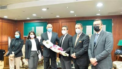 طلاب جامعة أسيوط يقدمون الورود لمدير الأمن ورجال الشرطة