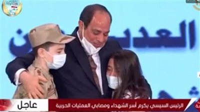 في مشهد لافت ومشاعر جياشة احتضن الرئيس السيسي نجلي الشهيد مصطفى عبيدو كحضن الأب لابنه وقام بتقبيلهما