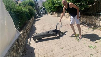 فنان إسرائيلى يلتقط صوره بجوار بقايا صاروخ بعد أن أمطرت المقاومة تل أبيب بالصواريخ