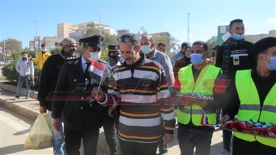 رجال الشرطة يوزعون الحلوى والورد والأعلام على مواطني كفر الشيخ