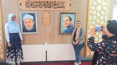 رواد معرض الإسكندرية للكتاب يلتقطون صورًا تذكارية مع صورتي الرئيس السيسي وشيخ الأزهر